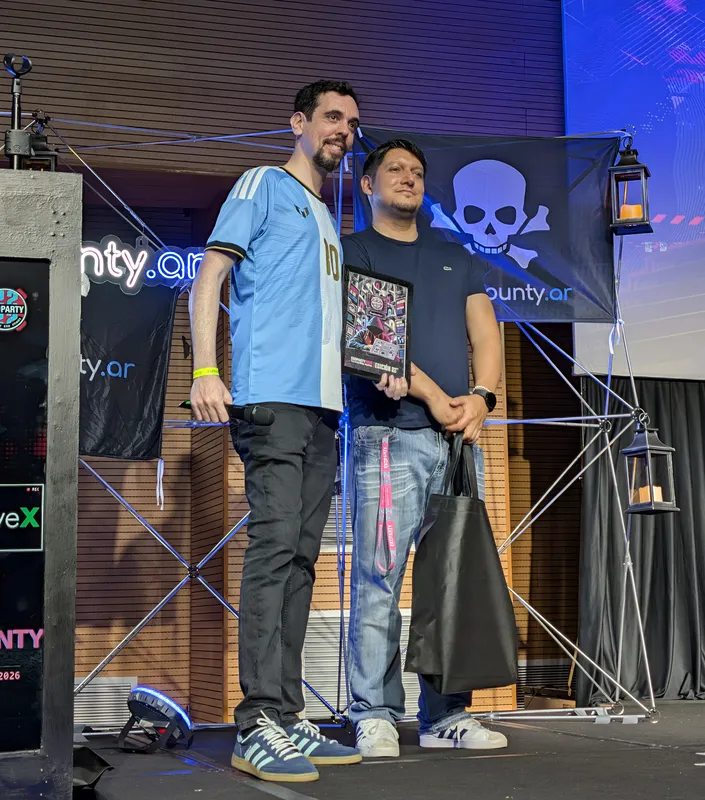 Alan Levy and Andrés Riancho on the Bug Bounty Argentina stage, one of them holding a plaque