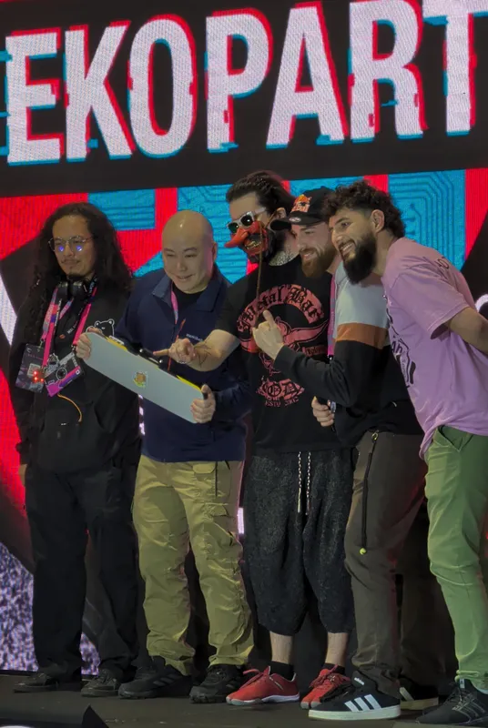 Five people from the wardriving on stage in front of the giant Ekoparty sign, one of them holding a grey panel